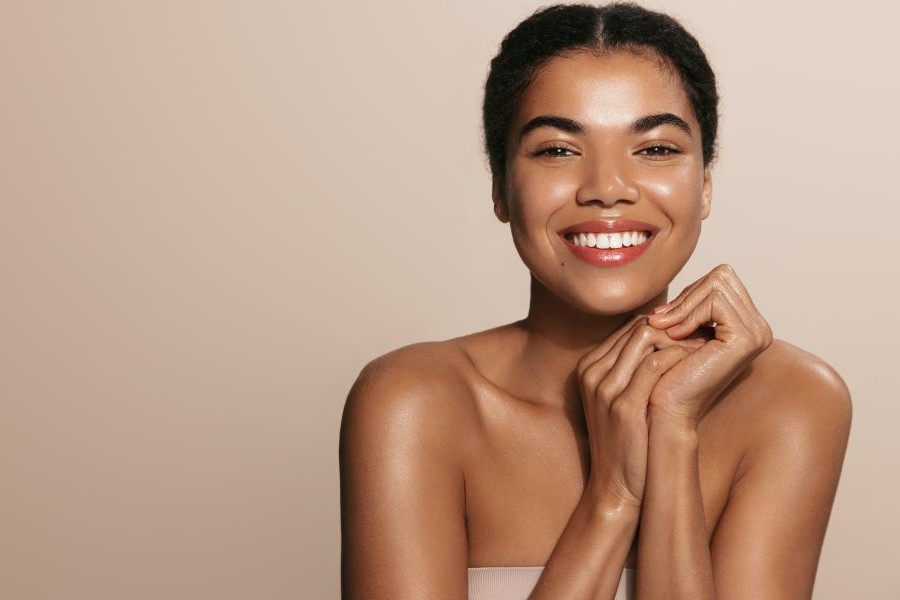 A beautiful young woman with amazing skin smiling.
